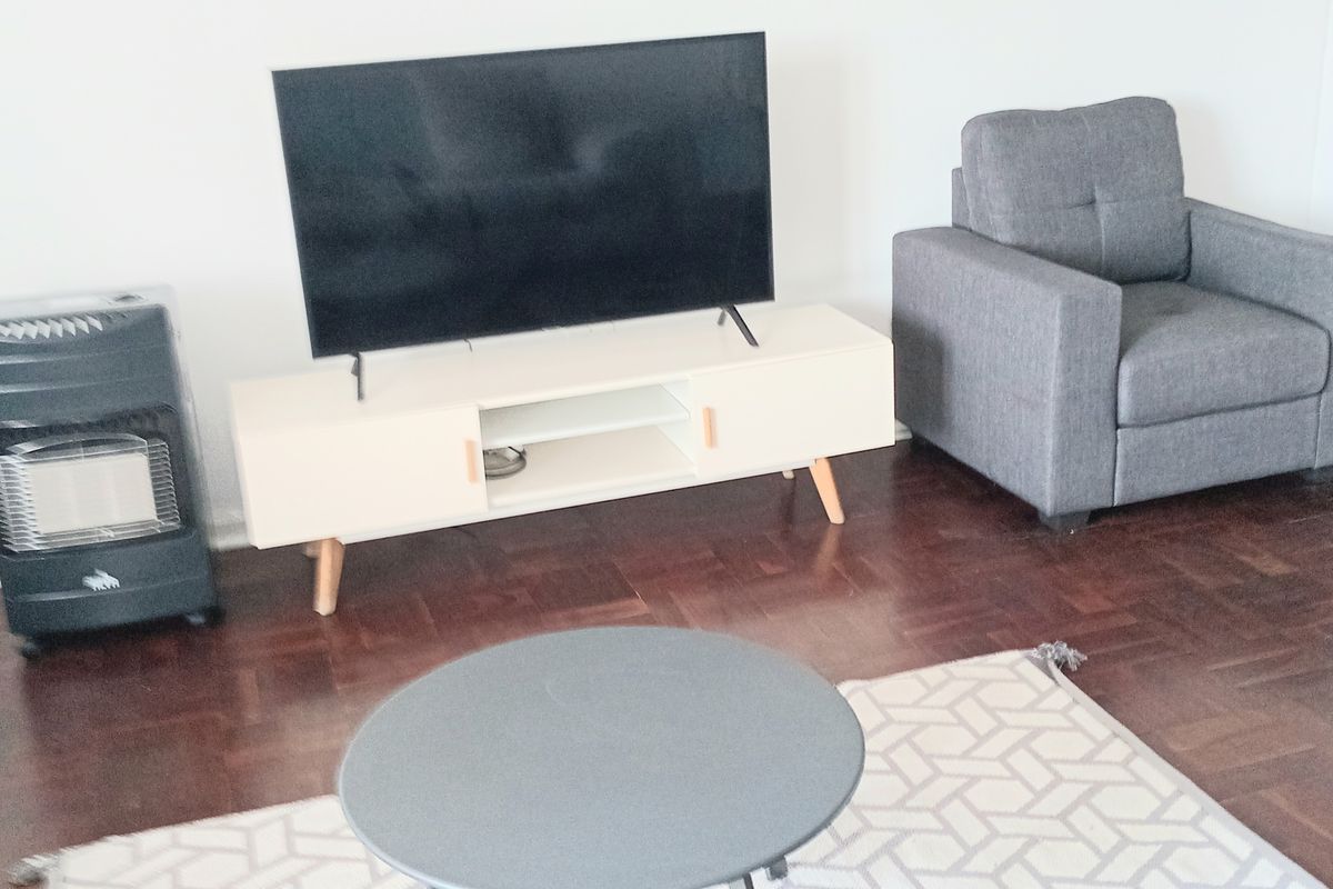 A living room area featuring dark parquet timber flooring and a neutral wall finish.