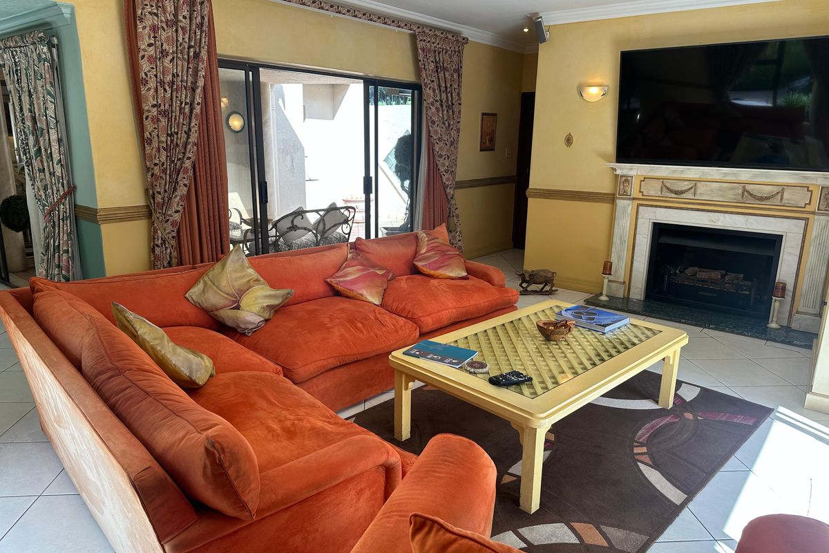 A spacious living room featuring a built-in fireplace with a decorative mantel and large sliding glass doors leading to an outdoor patio area.