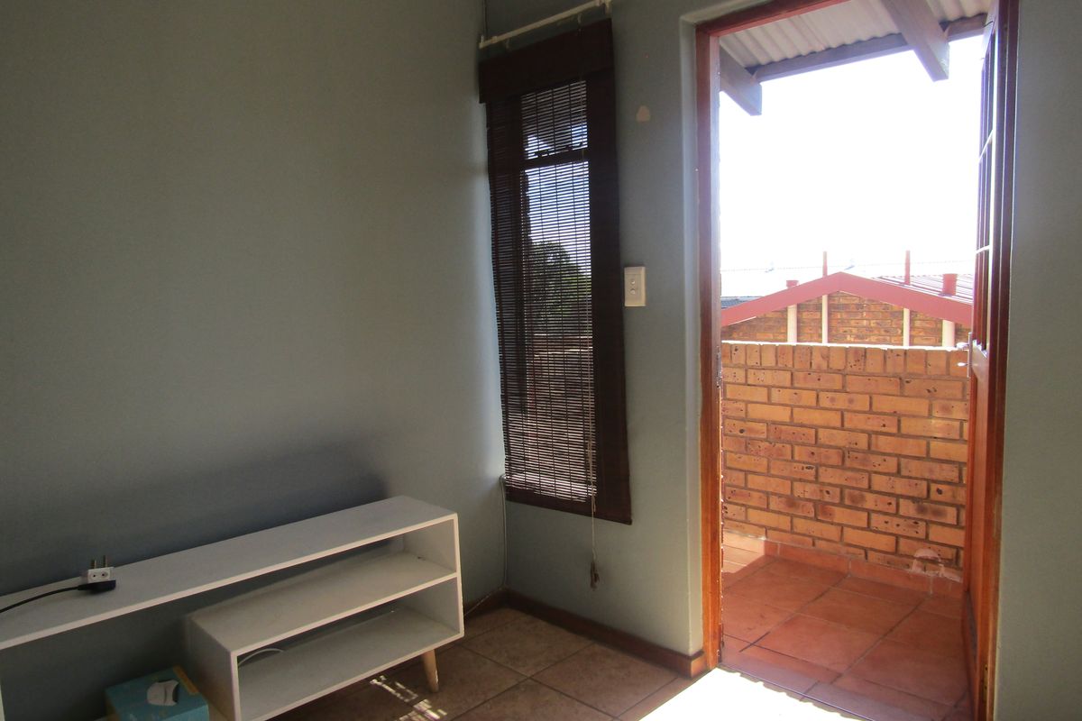 A bedroom featuring tiled flooring, a bamboo blind, and direct access to an outdoor balcony area.