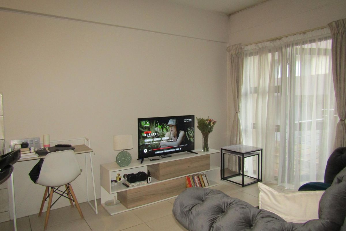A bright living room featuring tiled flooring and large sliding glass doors that provide access to an outdoor area.