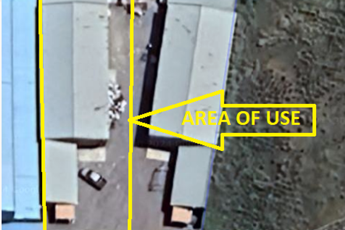 Aerial view of an industrial property showing warehouse structures and a designated yard area for operational use.