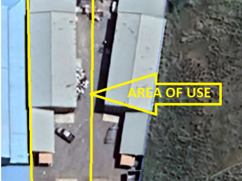 Aerial view of an industrial property showing warehouse structures and a designated yard area for operational use.