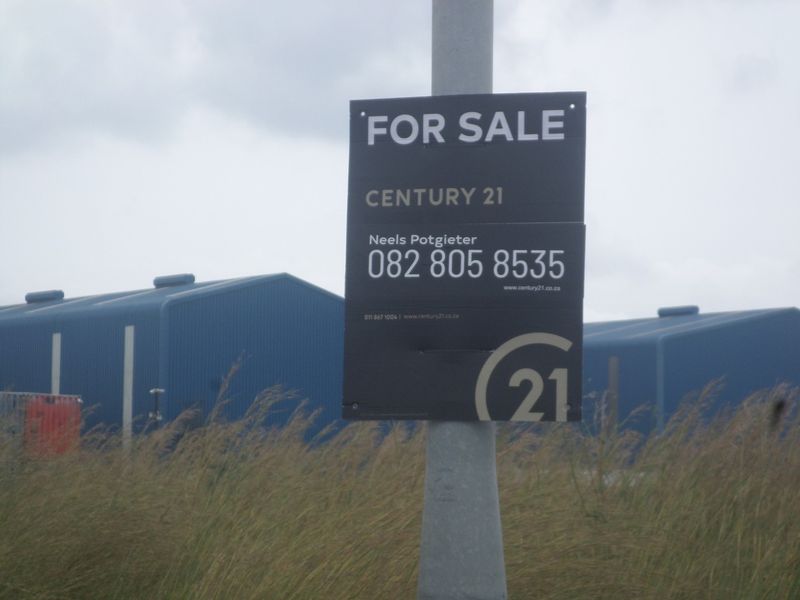 Industrial property featuring blue metal-clad warehouse structures, currently listed for sale.