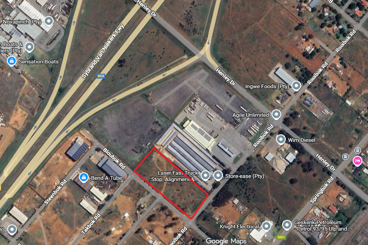 Aerial view of a vacant commercial land parcel situated in an industrial area with established road access and surrounding commercial infrastructure.