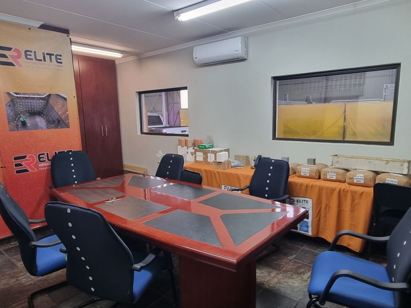 A functional office space featuring tiled flooring, a split-system air conditioner, and integrated lighting, suitable for administrative or meeting purposes.