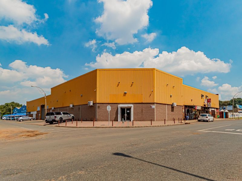 Corner-positioned industrial property featuring corrugated metal cladding, brick masonry base, and wall-mounted air conditioning units with convenient street-level access.