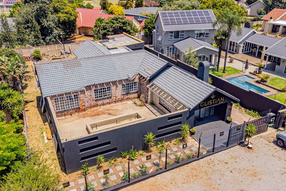 Aerial view of a property featuring a tiled roof, dark exterior facade, and an unfinished courtyard area with significant renovation potential.