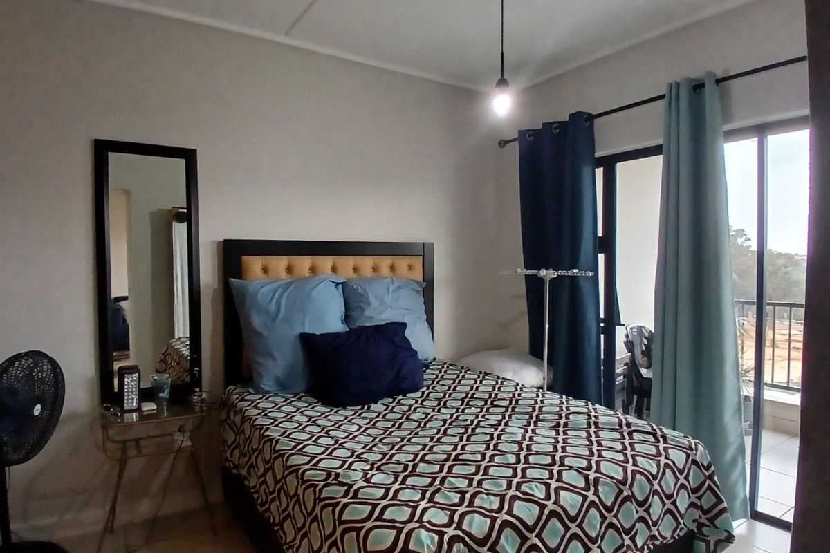 A bedroom featuring a sliding glass door that provides access to an outdoor balcony area, allowing for natural light and ventilation.
