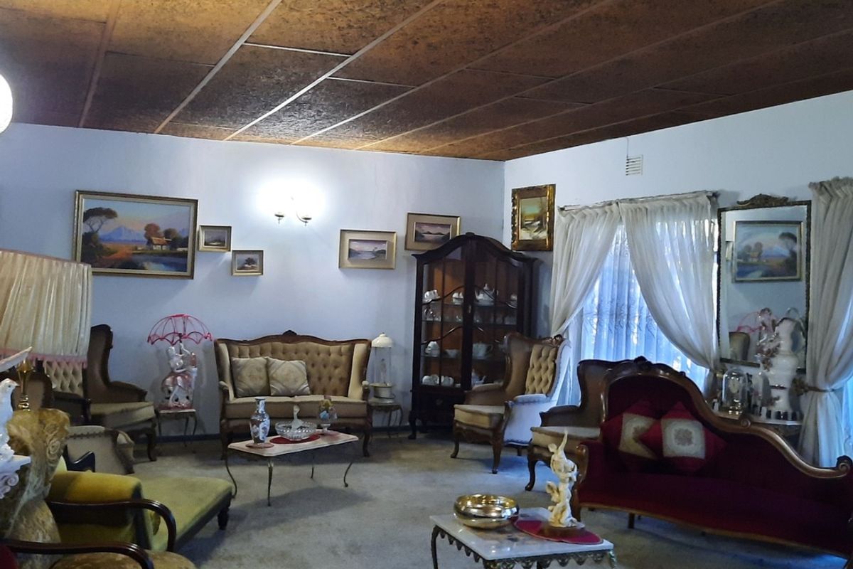 Spacious living room featuring a unique textured ceiling and large windows, offering a traditional layout with ample space for seating arrangements.