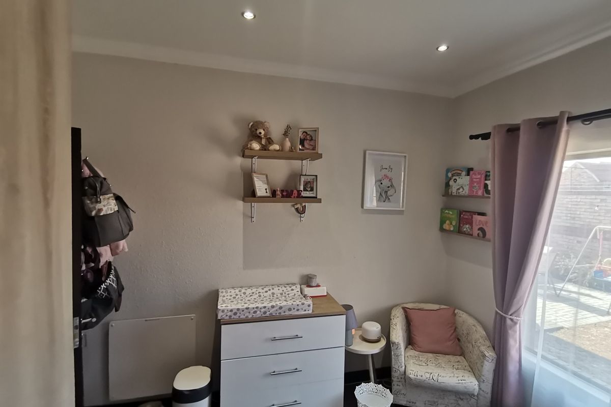 A well-maintained bedroom featuring recessed ceiling lighting, neutral wall tones, and large windows allowing for natural light.