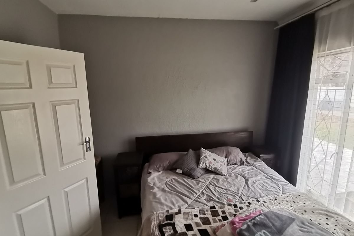 A bedroom featuring neutral wall tones, recessed ceiling lighting, and a sliding glass door providing natural light and access to the exterior.