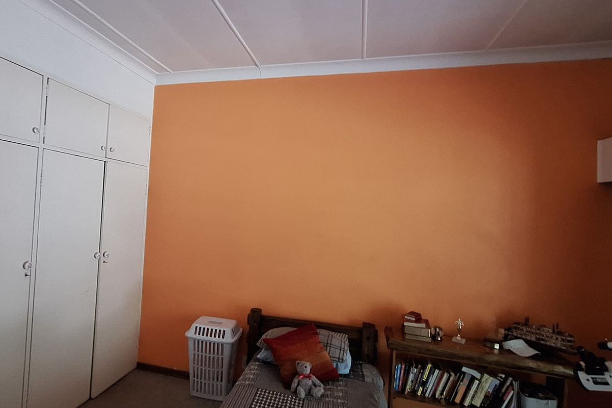 A bedroom featuring built-in cupboards with ample storage space and a neutral ceiling finish.