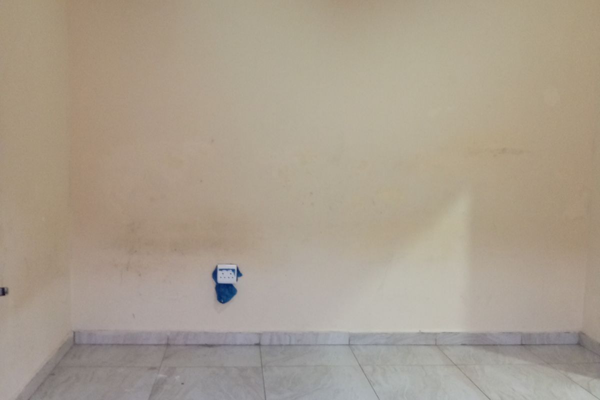 An empty room featuring light-colored tiled flooring, a textured ceiling, and basic electrical fixtures, ready for personalization.