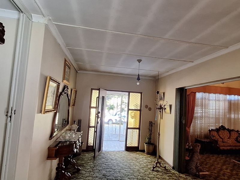 Entrance hall featuring a security gate, tiled ceiling, and access to the adjacent living area through a sliding door.