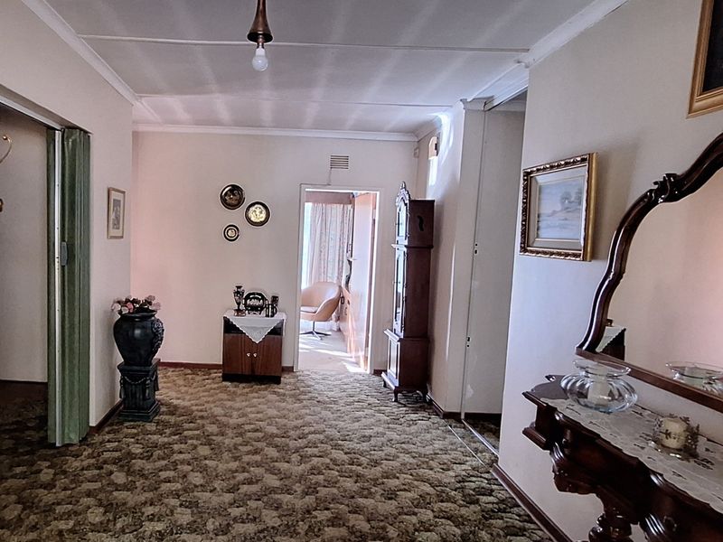 Spacious interior hallway featuring patterned carpet flooring and access to adjacent rooms through a sliding door.