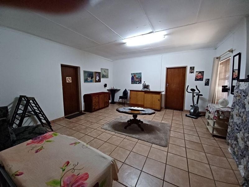 Spacious living area featuring tiled flooring and multiple access points, offering a functional layout ready for modernization and updated finishes.