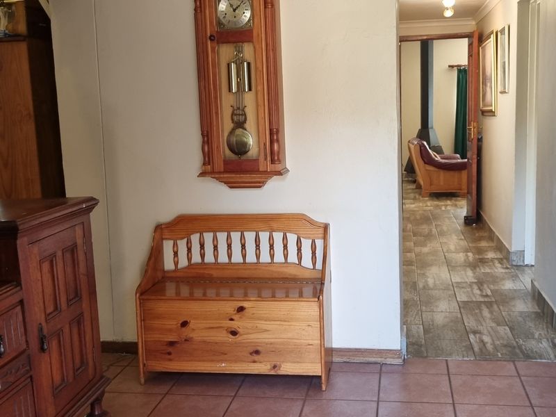 A functional hallway featuring tiled flooring and a transition into an adjacent living area with wood-look floor tiles.