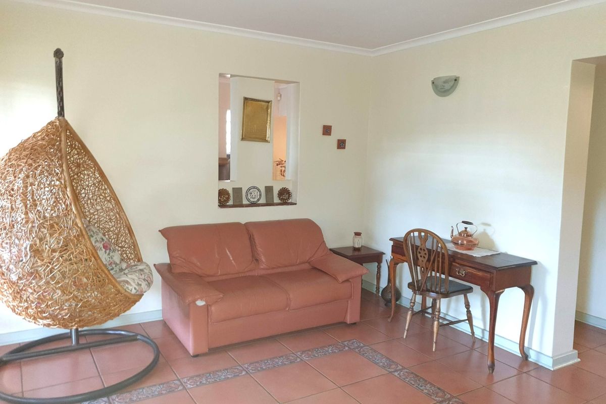 A living room featuring ceramic tile flooring, a decorative wall niche, and coving, providing a functional and neutral space.