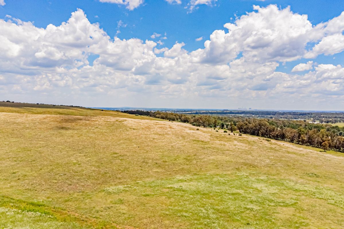 An aerial view of the expansive open pasture and landscape surrounding the farm property.