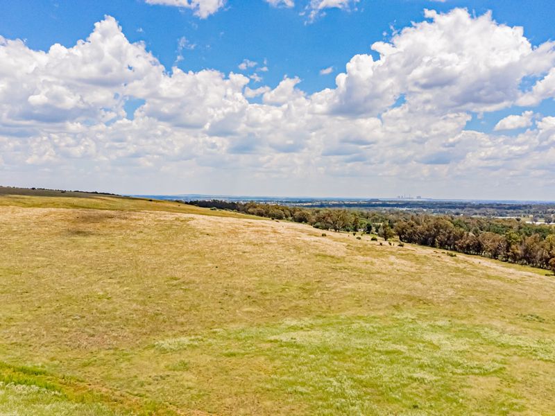 An aerial view of the expansive open pasture and landscape surrounding the farm property.