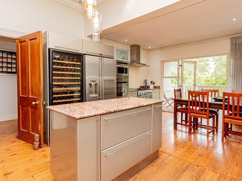 Spacious open-plan kitchen and dining area featuring a central island with granite countertops, built-in appliances, and direct access to an outdoor patio.