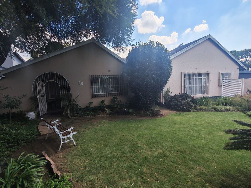 Front elevation of a single-story residential house featuring a lawn, paved walkway, and security-fitted windows and entrance.