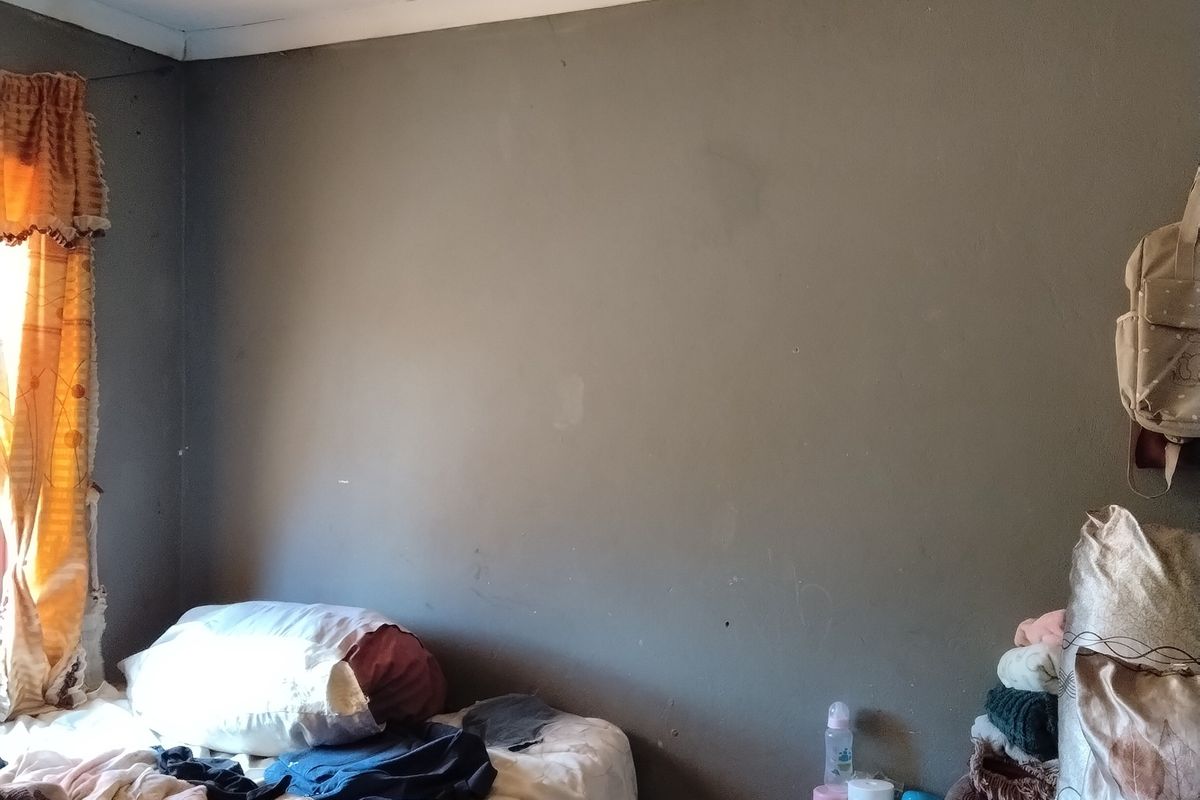 A bedroom featuring grey painted walls, coving, and a simple pendant light fitting, requiring cosmetic updates to improve the overall finish.