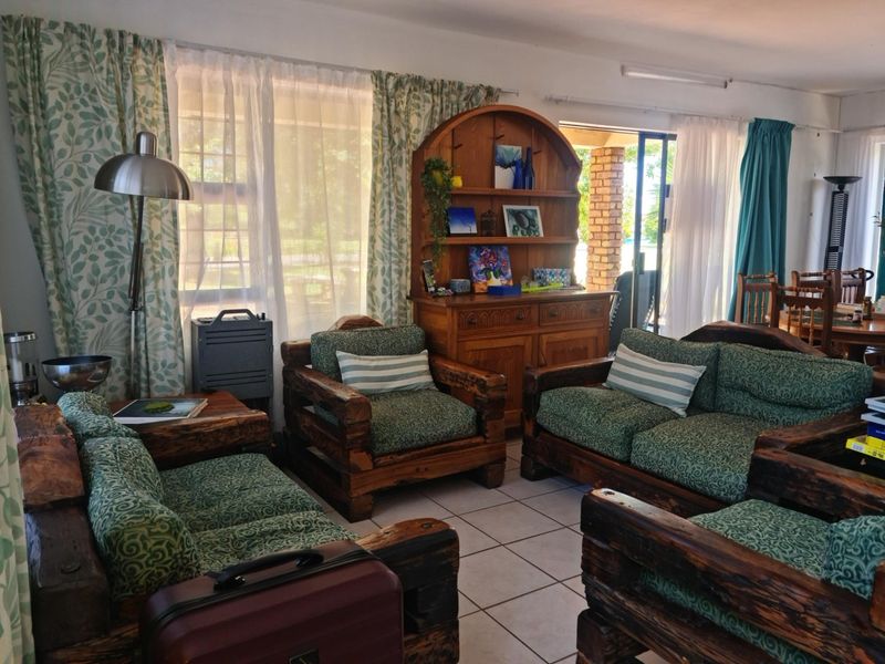 A living room area featuring tiled flooring and a sliding glass door providing access to the outdoor space.