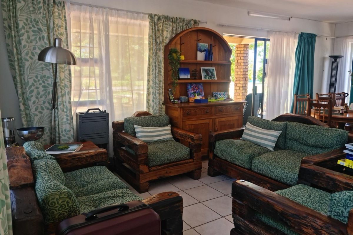 A living room area featuring tiled flooring and a sliding glass door providing access to the outdoor space.