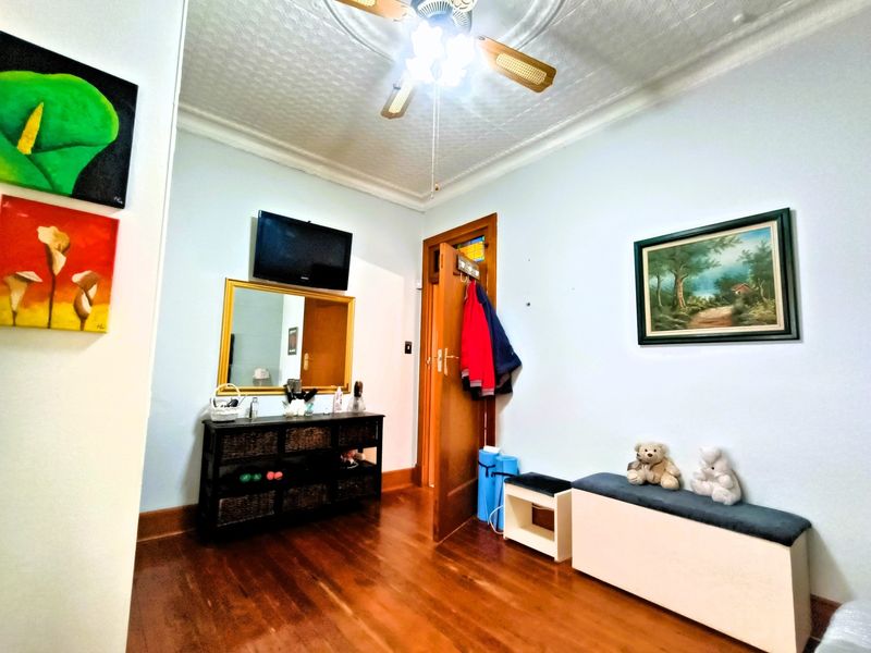 An inviting entry area featuring polished hardwood flooring, a decorative ceiling rose, and a classic timber door.