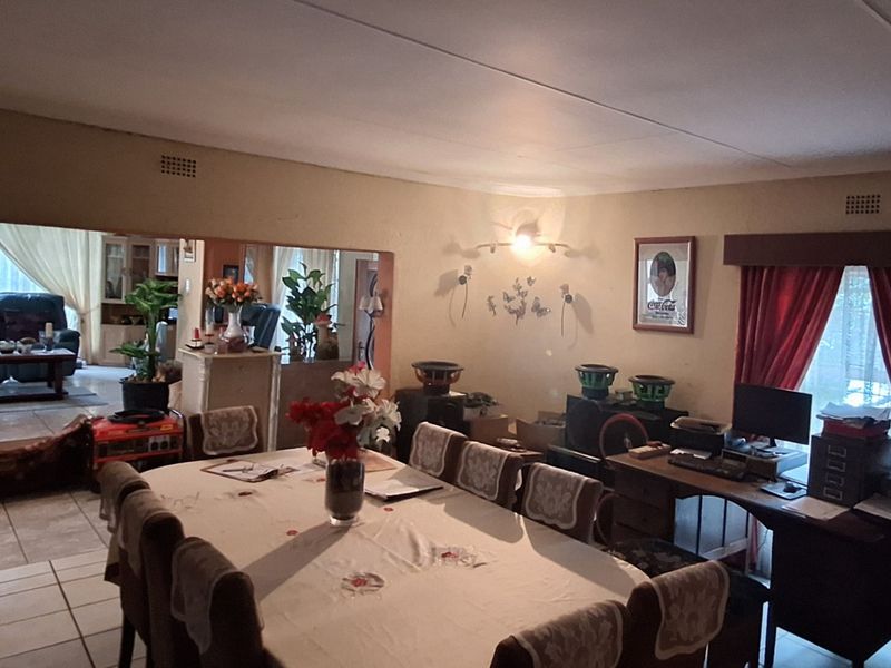Open-plan living and dining area featuring tiled flooring and direct access to an adjacent lounge space.