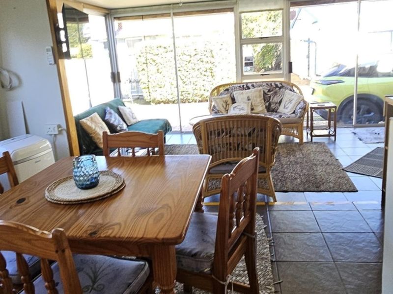Open plan living and dining area featuring tiled flooring and large sliding glass doors providing access to the exterior.
