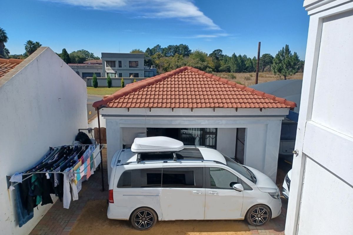 Rear exterior view showing a detached garage structure with a tiled roof and paved driveway area.