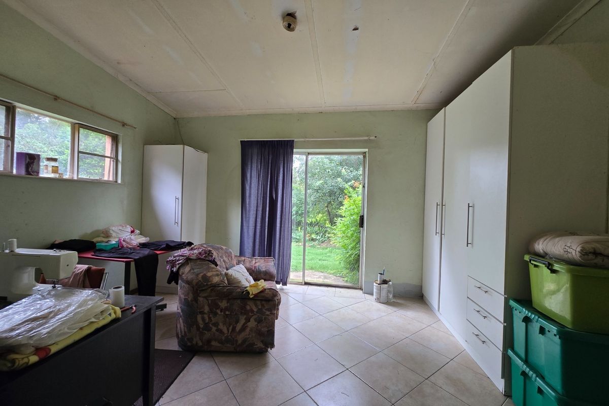 Bedroom featuring built-in cupboards, tiled flooring, and a sliding glass door providing direct access to the garden.