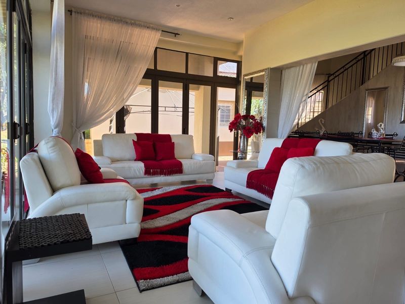 Spacious living area featuring tiled flooring, recessed lighting, and large aluminium sliding doors providing access to the outdoor space.