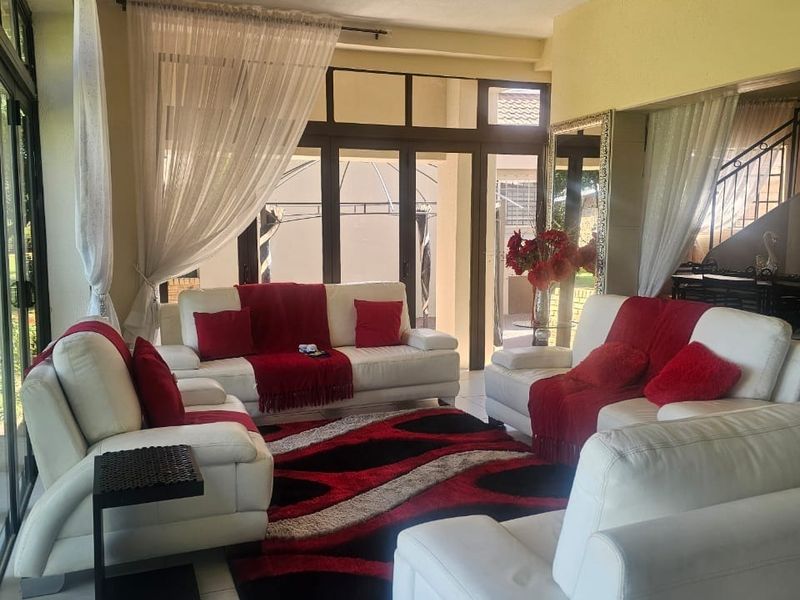 A bright living room featuring large glass sliding doors that provide ample natural light and direct access to the outdoor area.