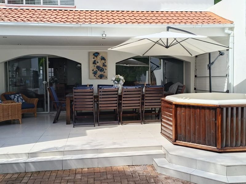 A covered patio area featuring tiled flooring, recessed lighting, and direct access to the interior through sliding glass doors.