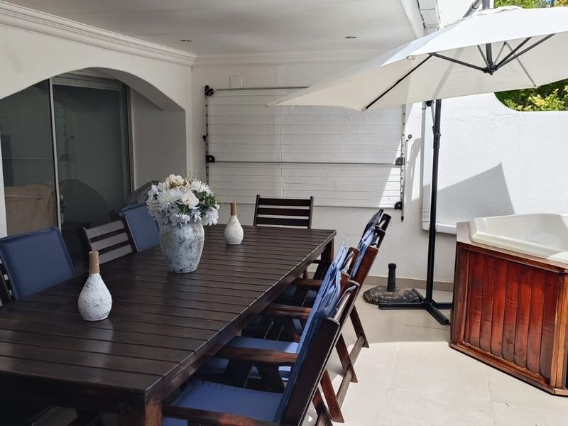 Covered patio area featuring a built-in spa, tiled flooring, and direct access to the interior through sliding glass doors.