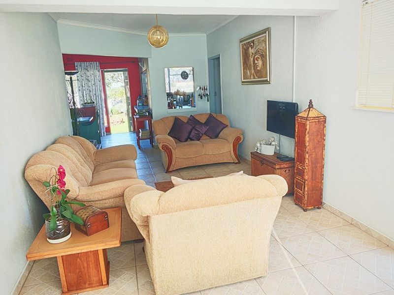 A living room area featuring tiled flooring and a sliding glass door leading to an outdoor space.