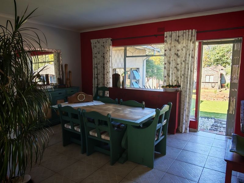Dining room featuring tiled flooring, a large window, and a sliding door providing direct access to the rear garden.