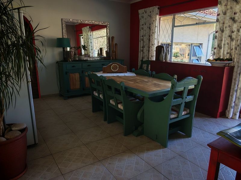 A dining room featuring tiled flooring, large windows providing natural light, and built-in cabinetry, with direct access to the outdoor area.