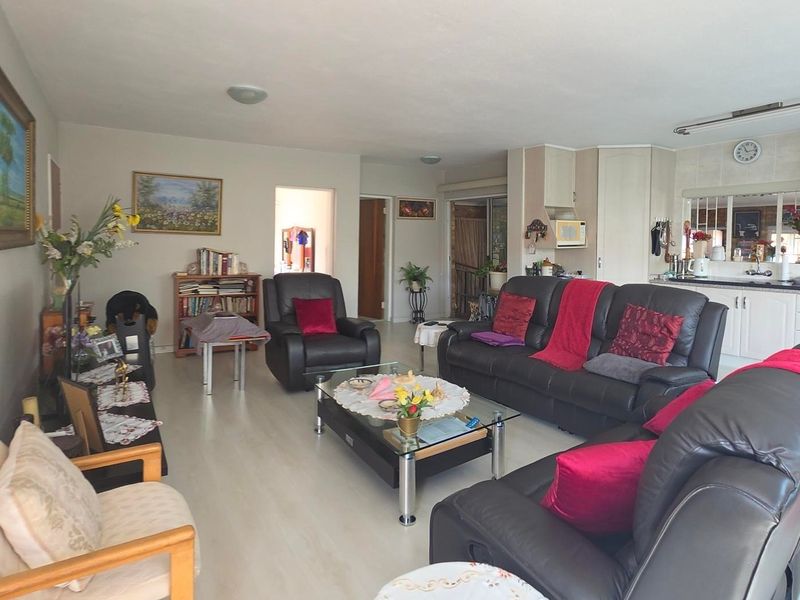Spacious open-plan living area featuring a functional kitchen with built-in cabinetry and integrated oven, seamlessly flowing into the lounge space.