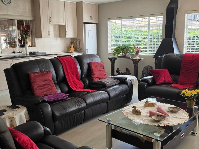 Open-plan living area featuring a functional kitchen with granite countertops and a cozy lounge area with a built-in fireplace.