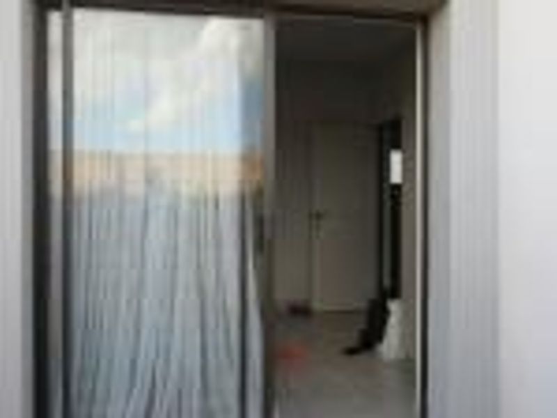 A view through a sliding glass door into an interior space, showing the transition between the exterior and the living area.