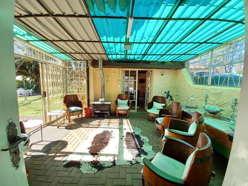 Covered patio area featuring brick paving, textured walls, and a built-in wood-burning stove, providing a sheltered outdoor living space.