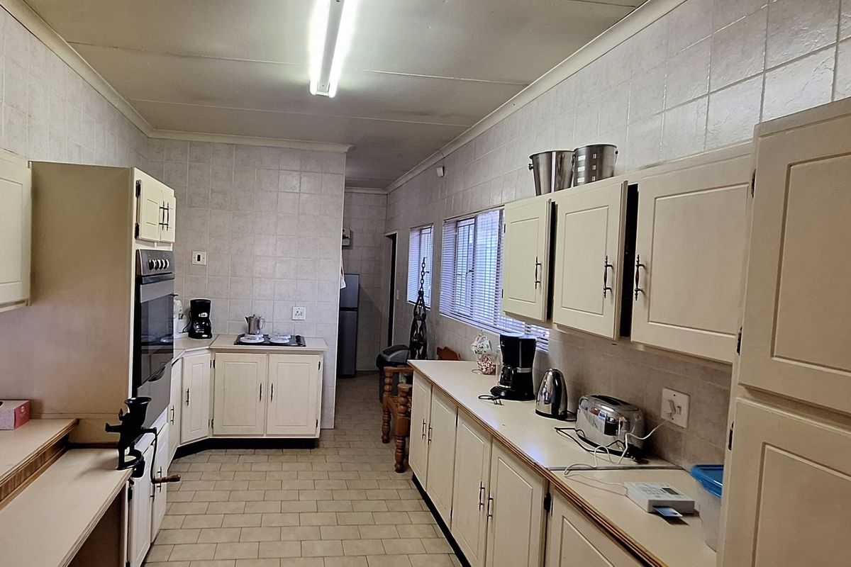 A functional kitchen featuring extensive built-in cabinetry, tiled wall finishes, and a built-in oven, offering a practical layout with potential for modern updates.
