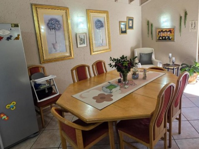 A dining area featuring tiled flooring and textured walls, providing a functional space for family meals.