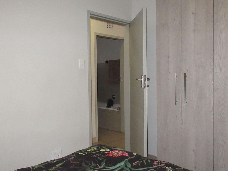 Bedroom featuring built-in cupboards and direct access to an en-suite bathroom.