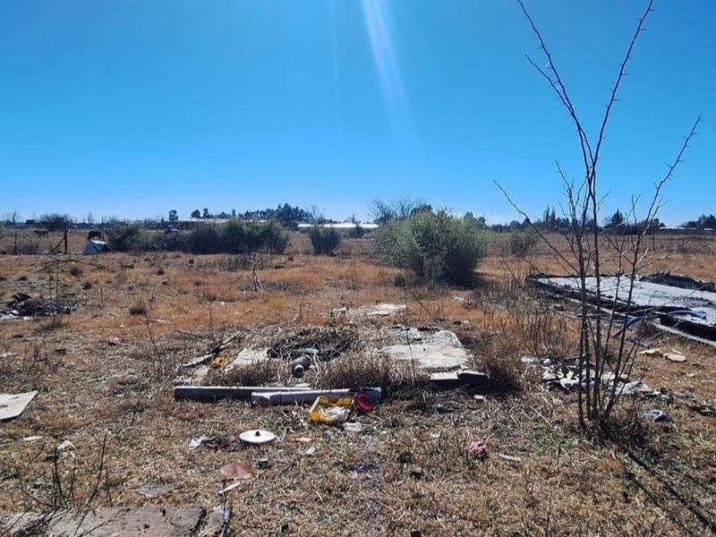 Expansive undeveloped land featuring a weathered concrete slab foundation, suitable for future development or landscaping projects on this small holding.