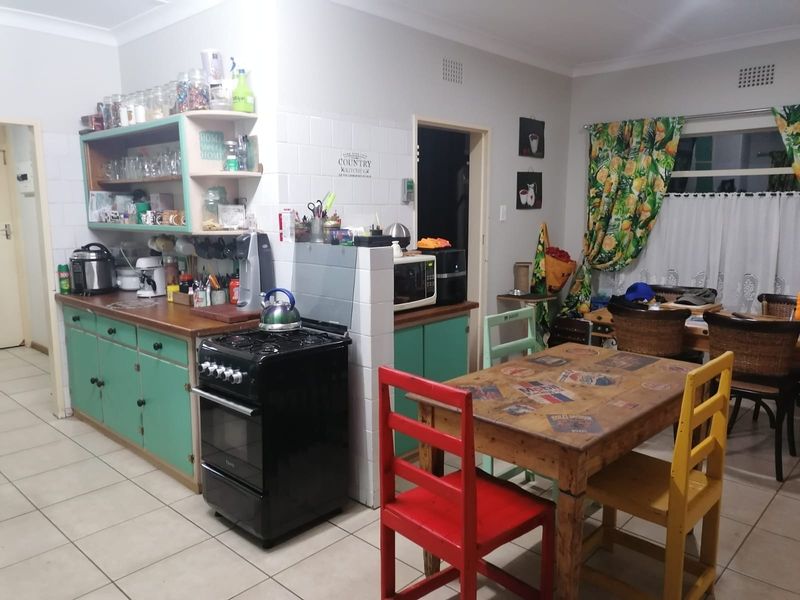 A functional kitchen featuring built-in cabinetry, a gas stove, and tiled flooring, offering a practical layout with potential for modern updates.